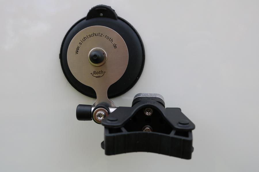 Runde Saugnapf‑Halterung mit Metallplatte und Roth‑Gravur, darauf eine verstellbare schwarze Kunststoff‑Klemme zur Befestigung des Brausehalters